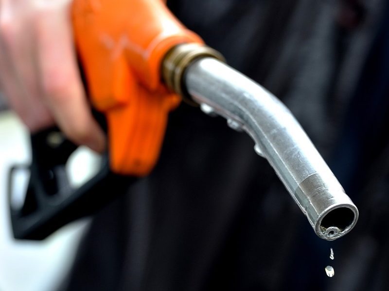 A Man Finishes To Fill Up At A Gas Stati